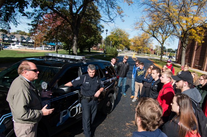 Professor and police officer talk with students.