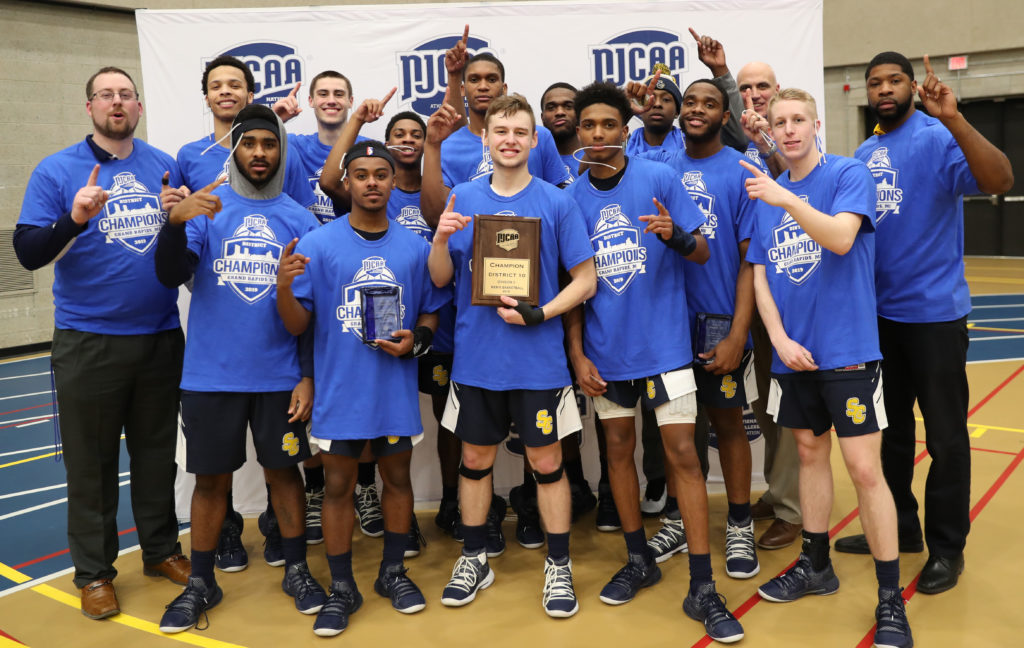 Men's basketball team poses after earning the NJCAA Division II District X Championship.