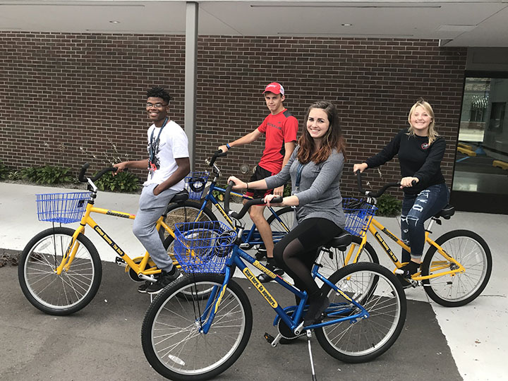 Four housing students ride SC4 bicycles.