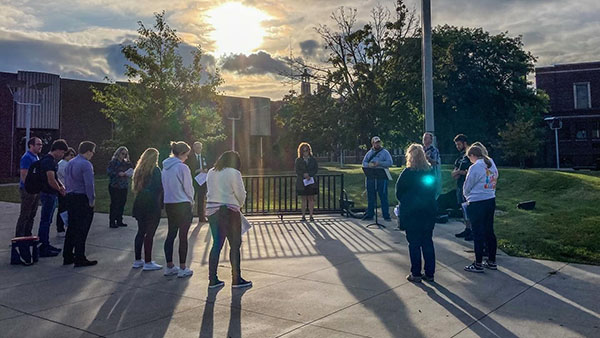 Student around the flag pole praying